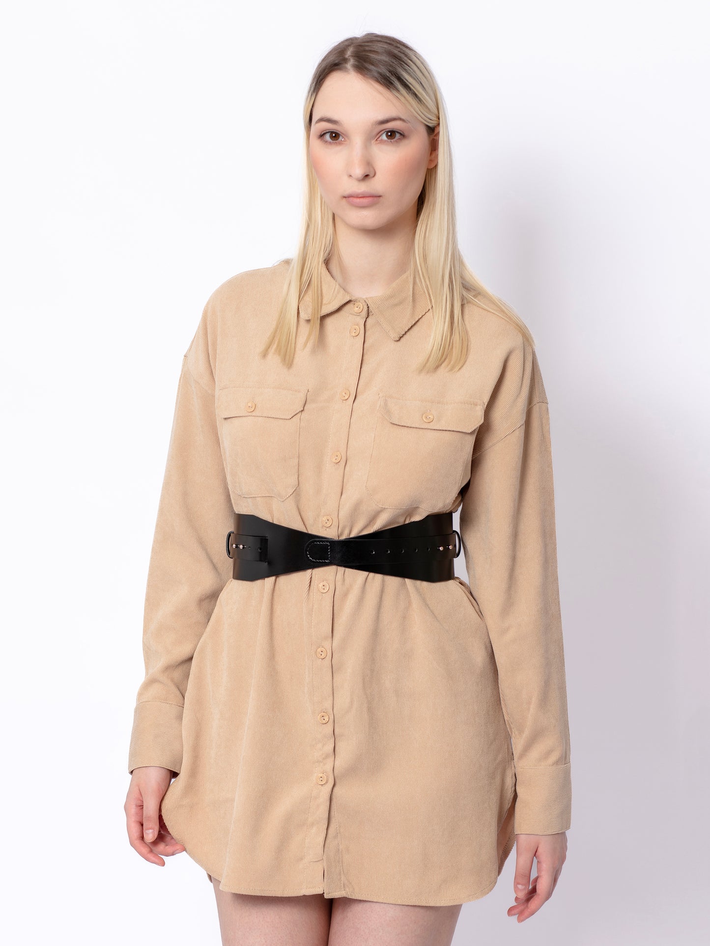 Front view of black leather corset belt worn by model over beige shirt.