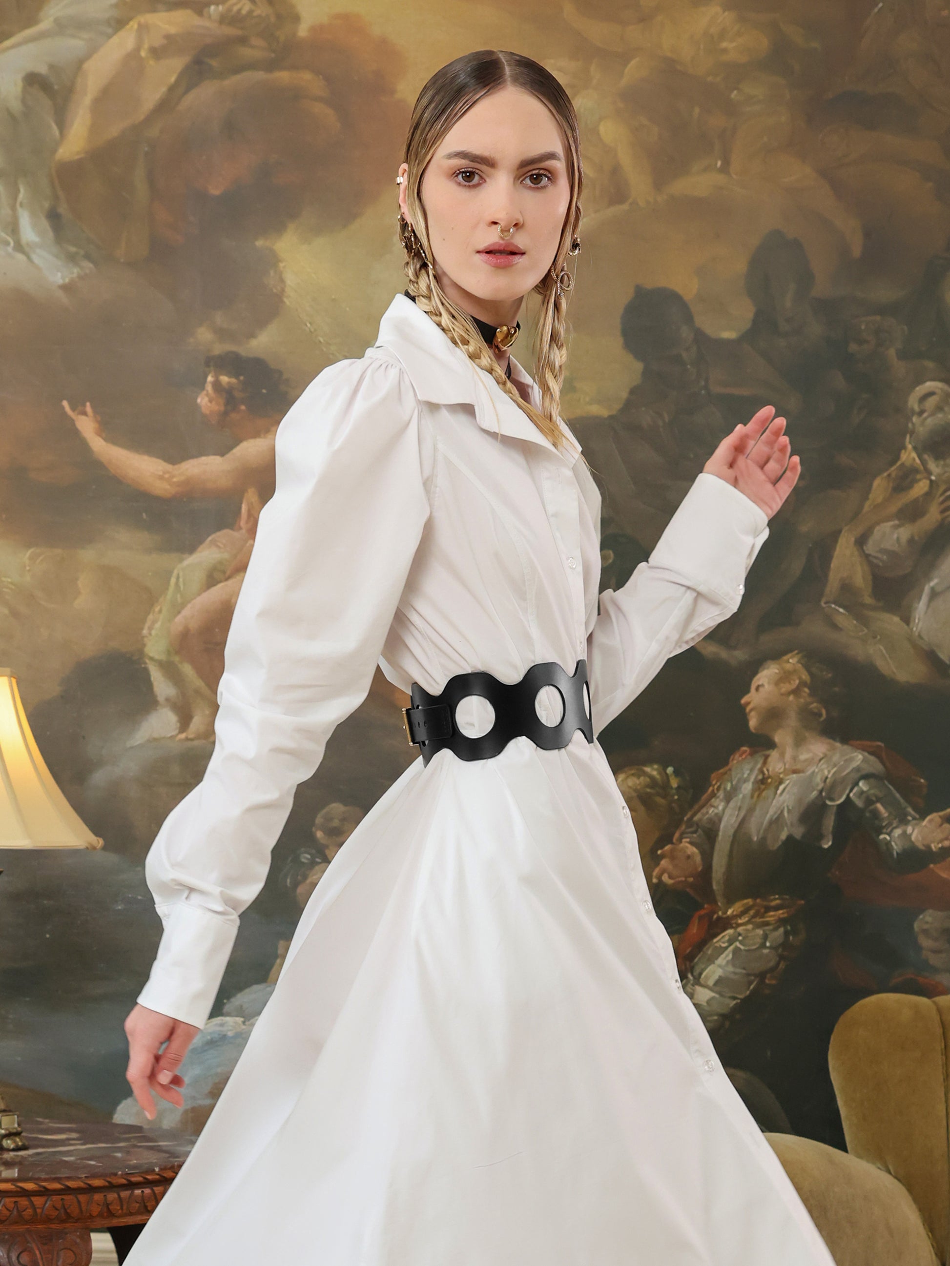 Adjustable wide black leather corset-style belt with cutouts, styled with a flowy white dress.