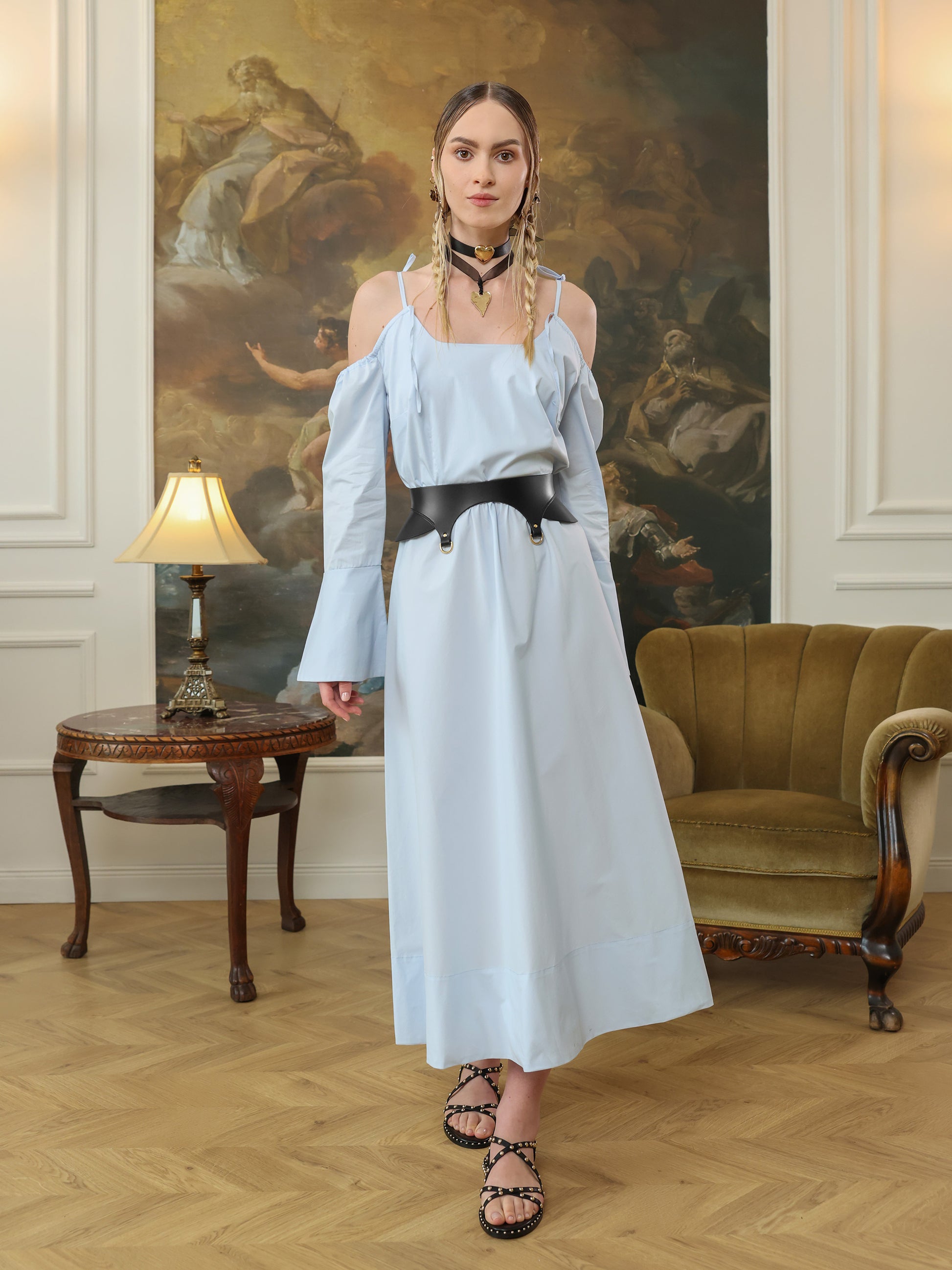 Full outfit with black wide waist belt on light blue maxi dress and studded sandals.