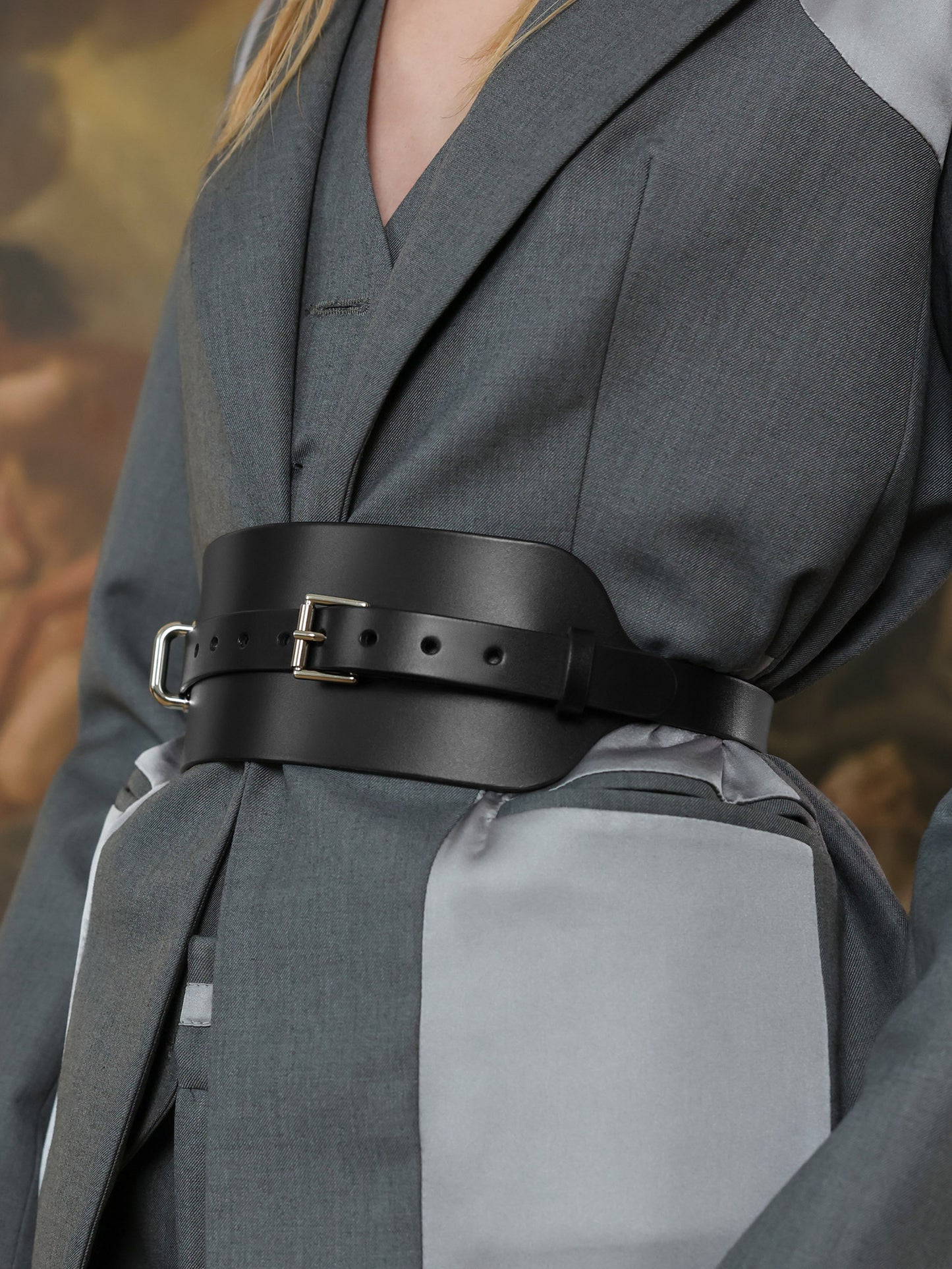 Stylish wide waist belt with buckle paired with structured grey jacket.
