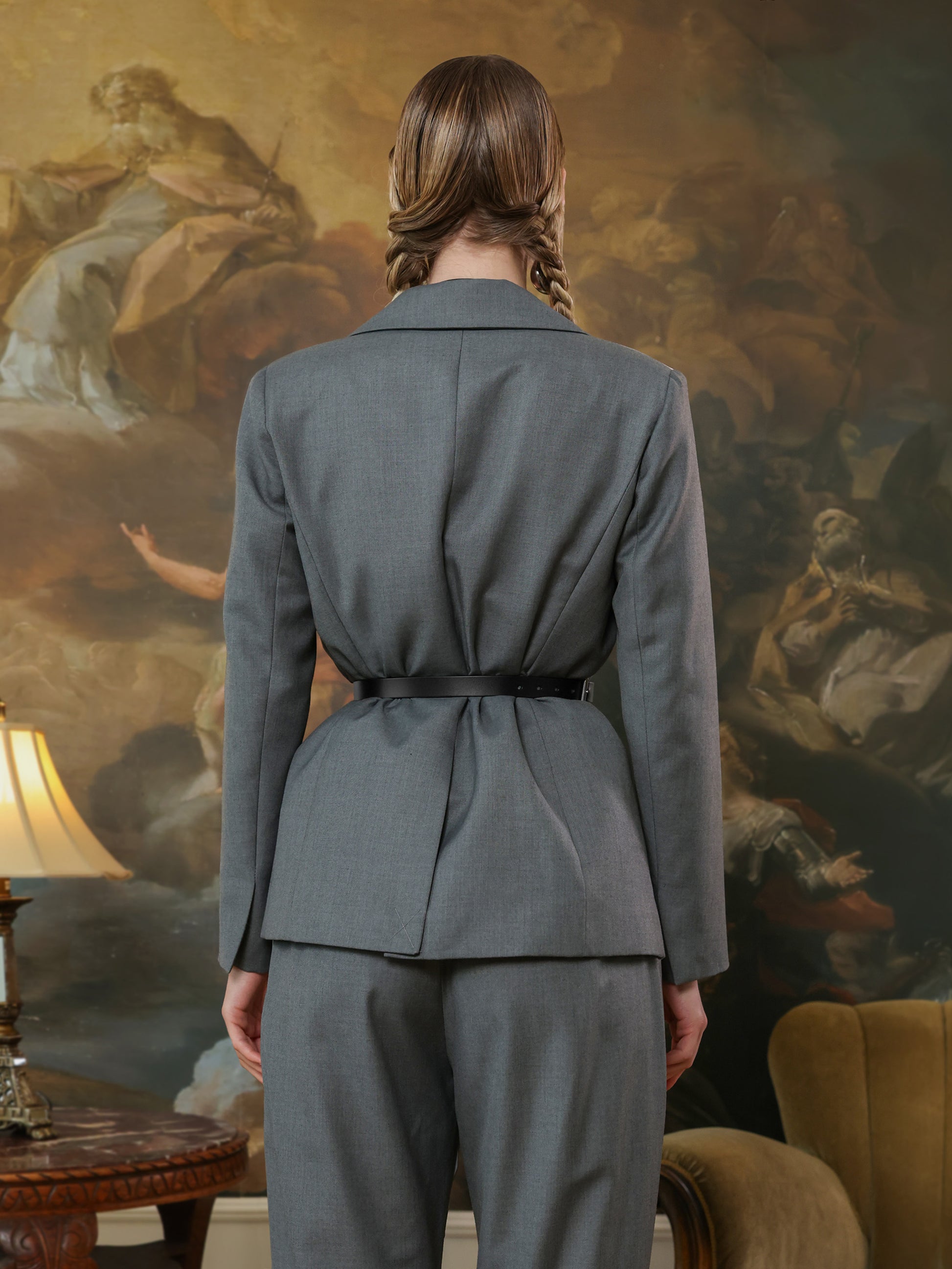 Wide waist cincher belt creating defined silhouette over grey suit set.