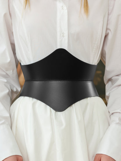 Close-up of a black leather hourglass corset belt over a white shirt dress, showing detailed stitching and sleek curves.