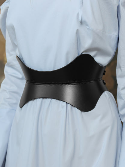 Women’s hourglass waist belt in black leather styled with a flowy pastel blue maxi dress.