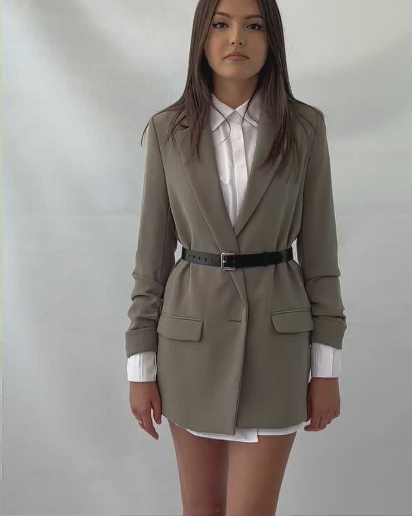 Video presenting the slim leather belt worn over green blazer.
