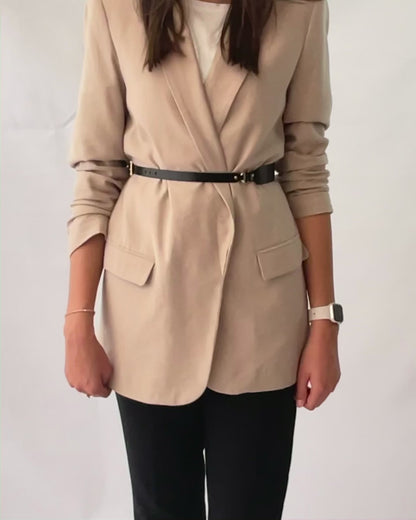 Black leather high waist belt fitted on beige blazer.