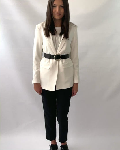 Round buckle leather belt fitted over white blazer.