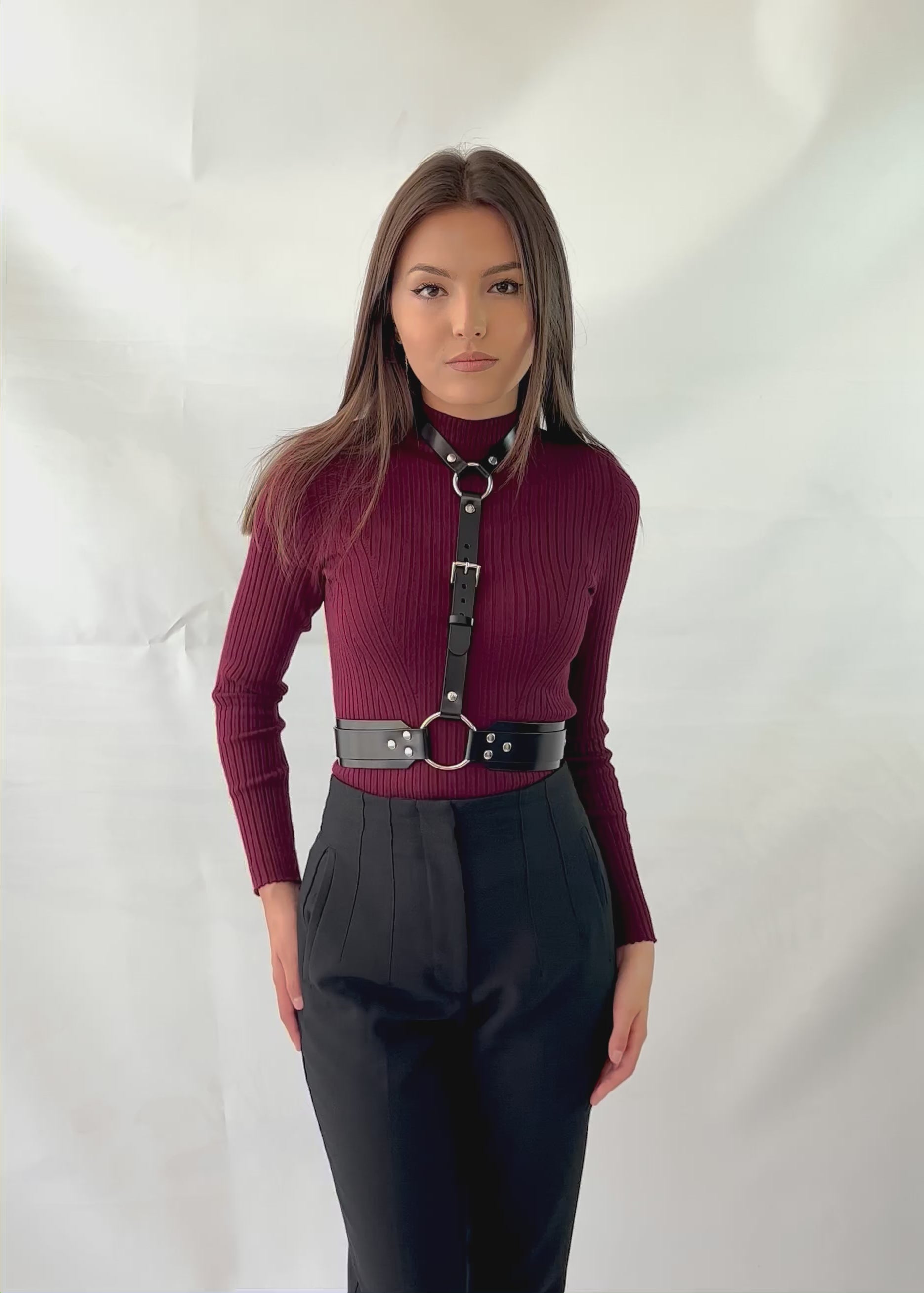 Neck to waist leather harness worn with burgundy turtleneck and black pants in a casual outfit.