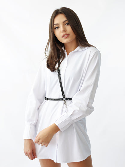 Slim leather chain harness worn over white shirt dress.