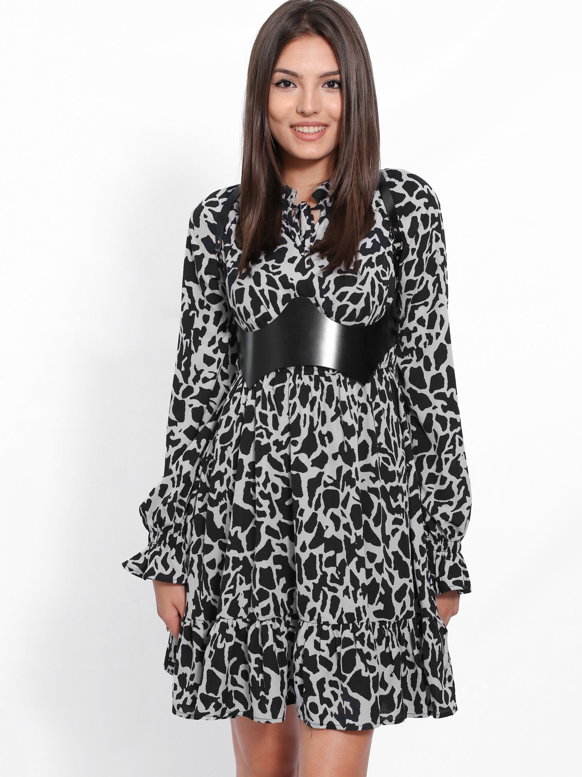 Black leather under breast harness worn with printed dress.