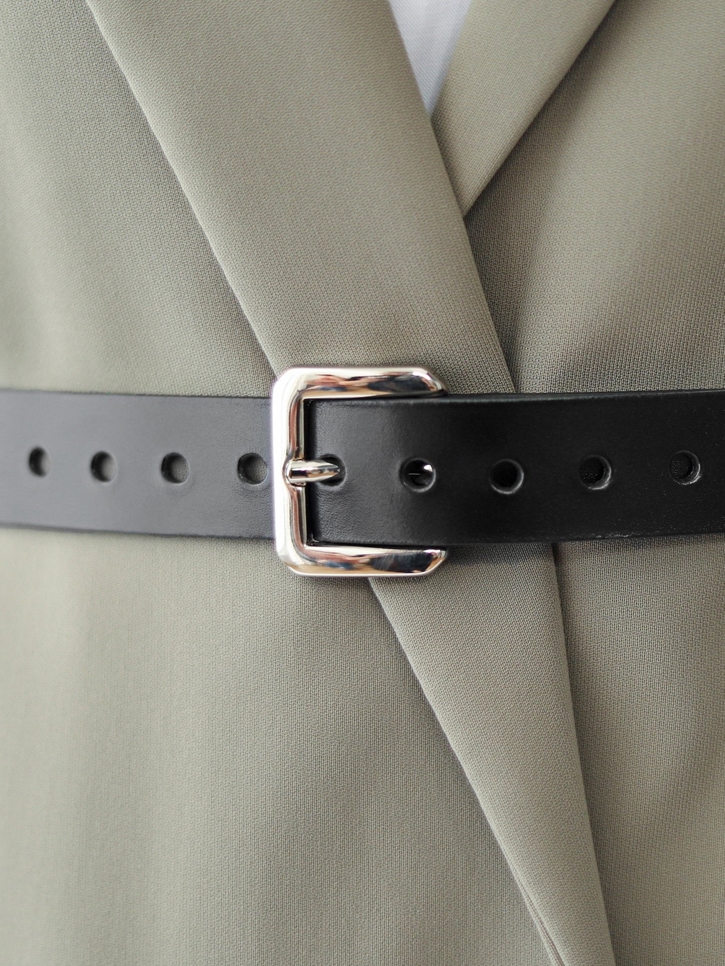Detailed view of black leather belt.