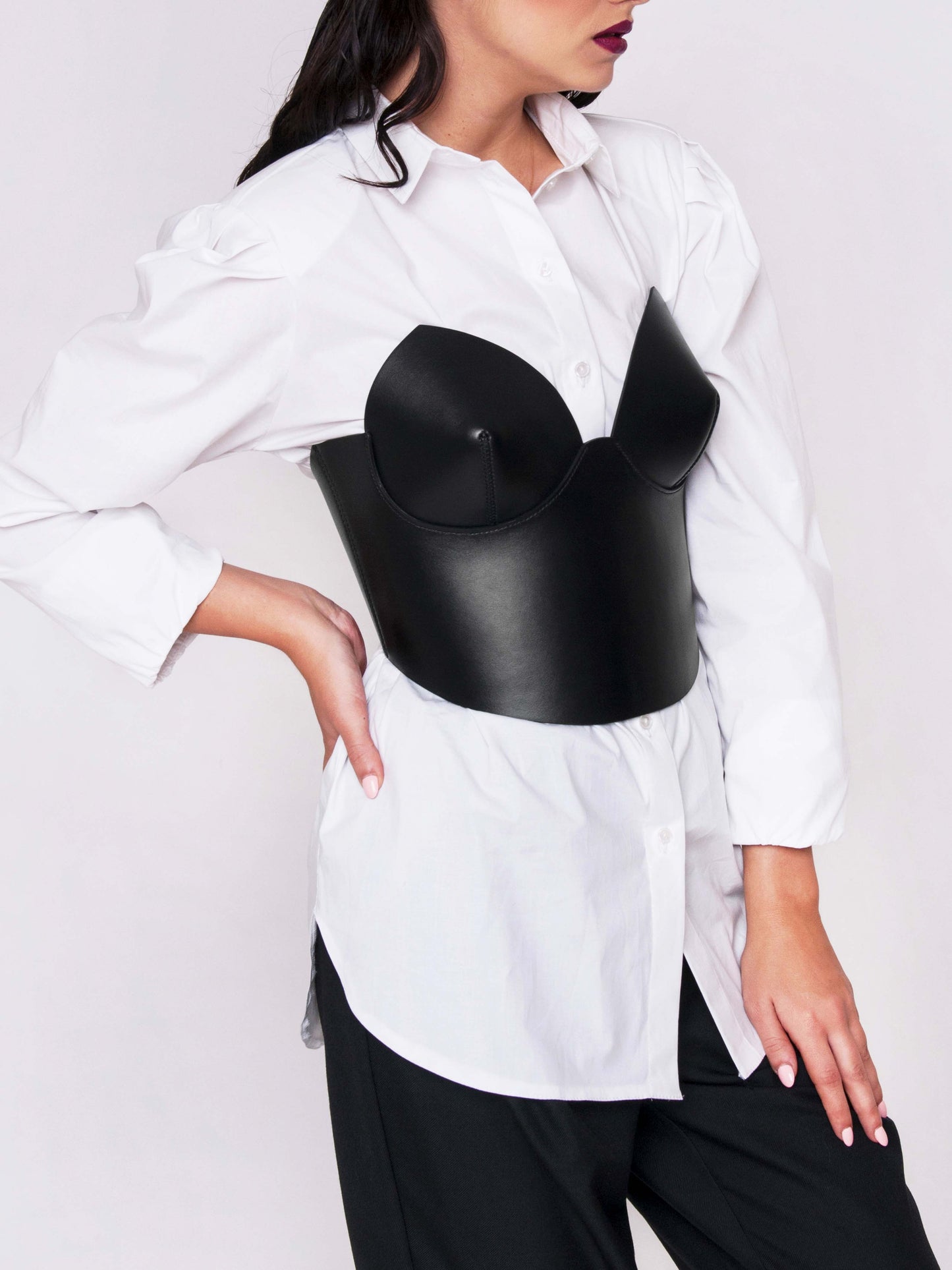Side view of the Corset Top Black worn by woman over white shirt.
