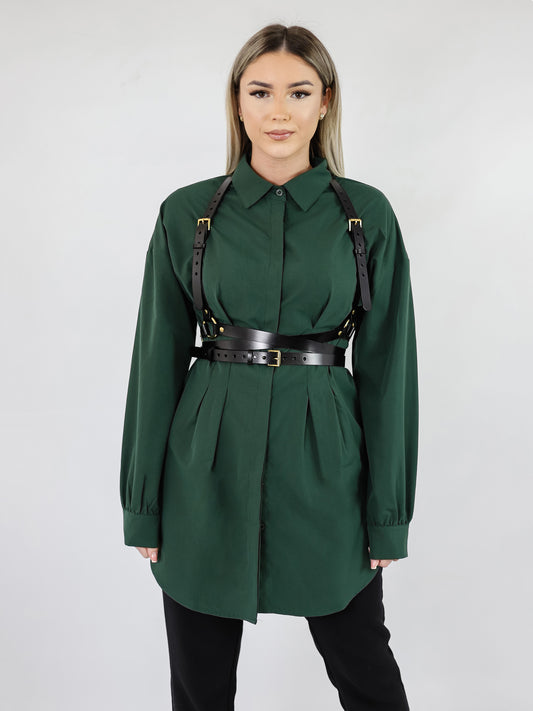 Black double belt leather harness worn over green shirt dress.