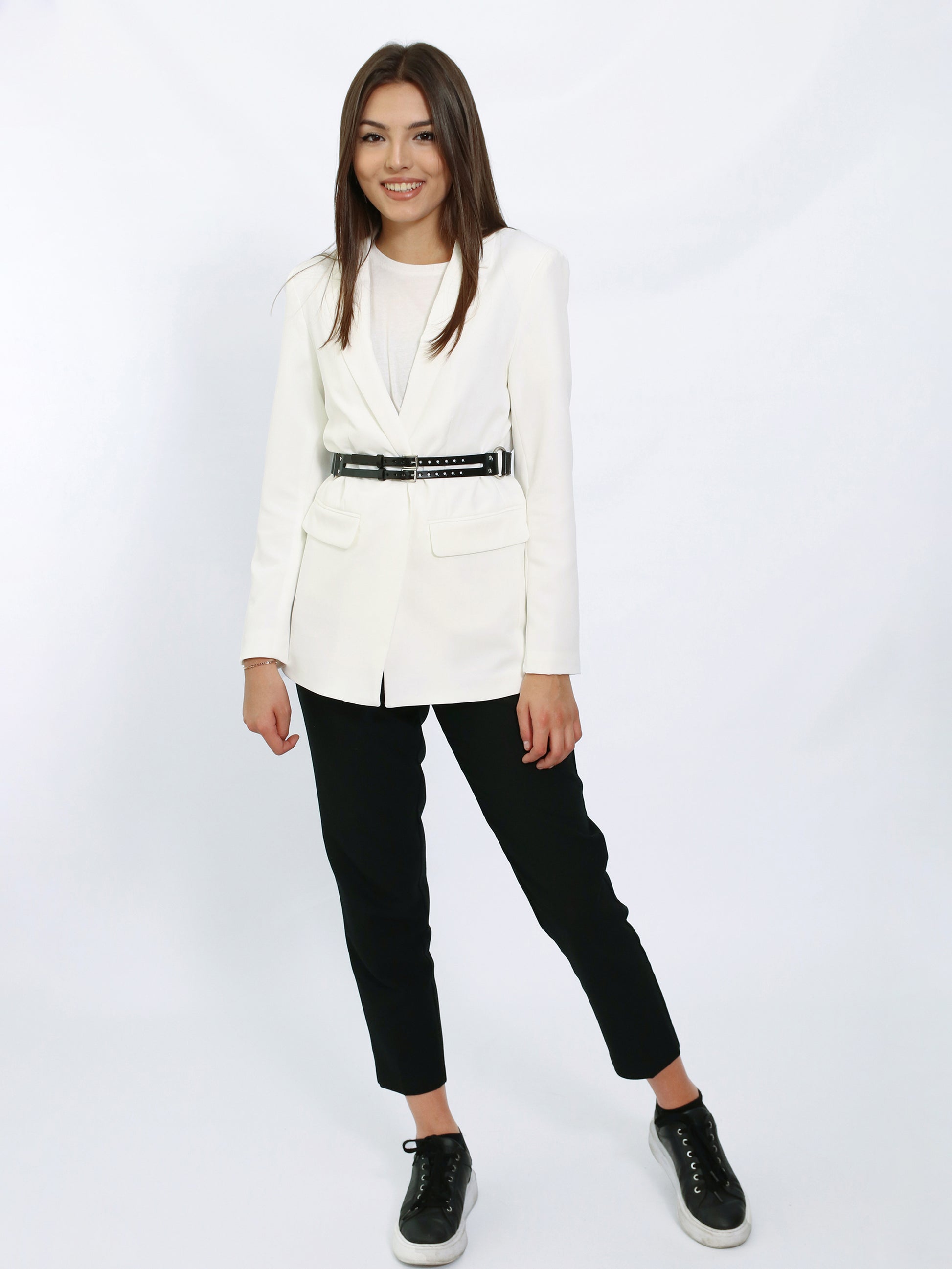 Black leather harness belt worn with white blazer.