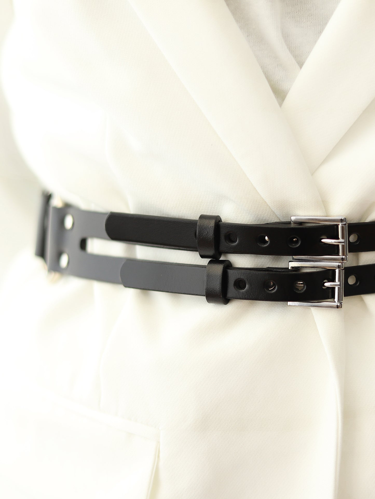 Detailed view of double buckle harness belt.