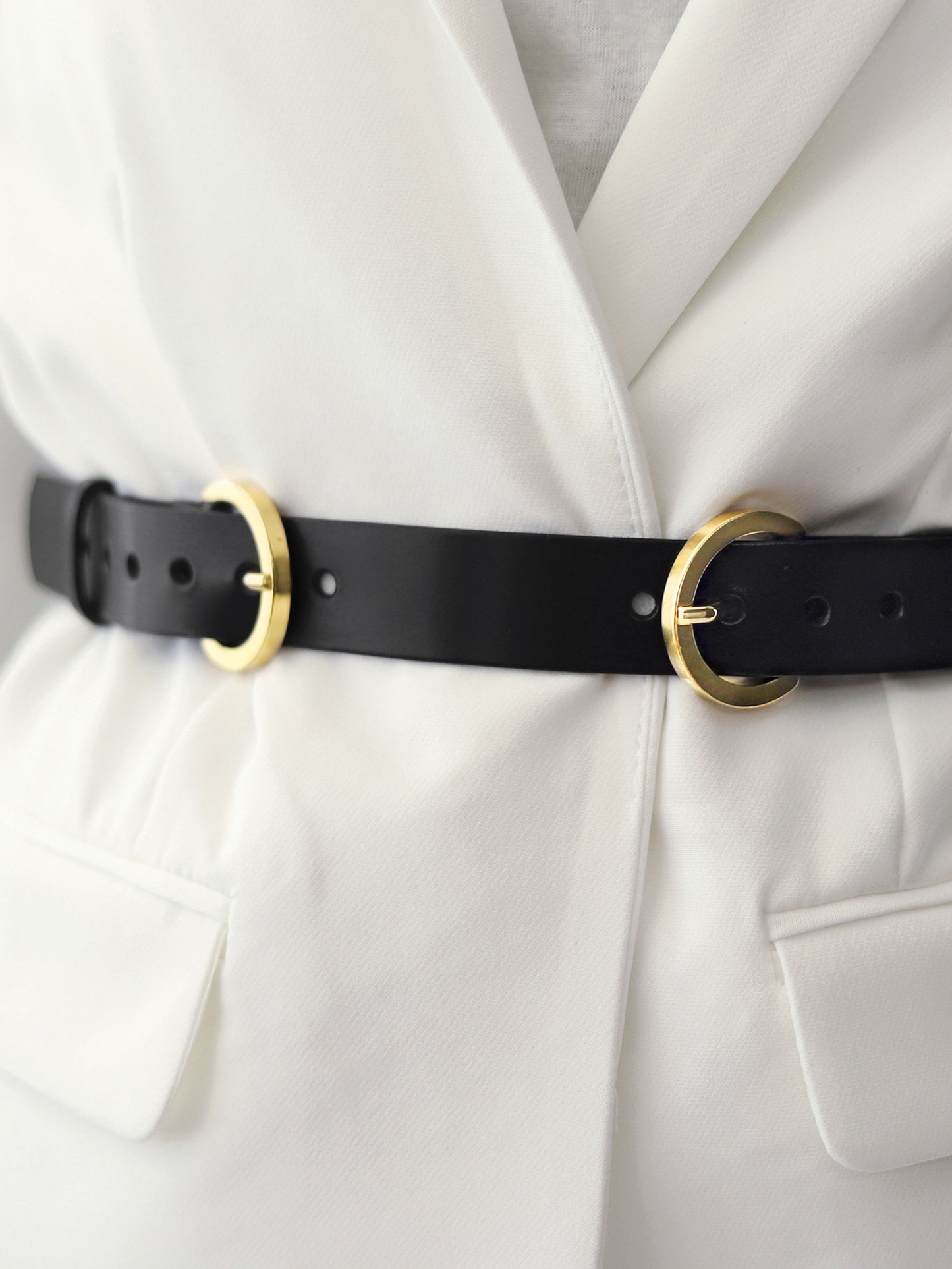 Detailed view of double buckle leather belt. 