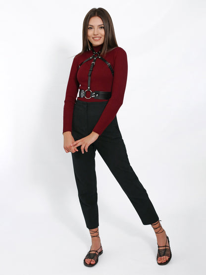 Black overbust harness worn over burgundy turtleneck.
