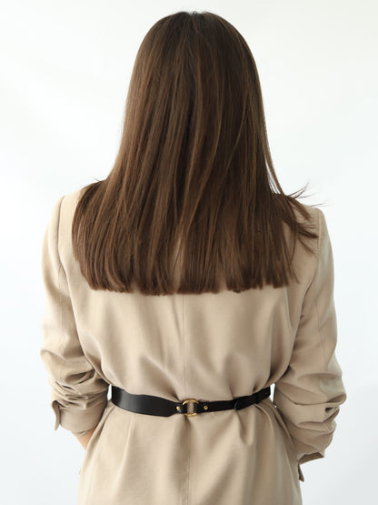 Back view of skinny leather belt worn over beige blazer.