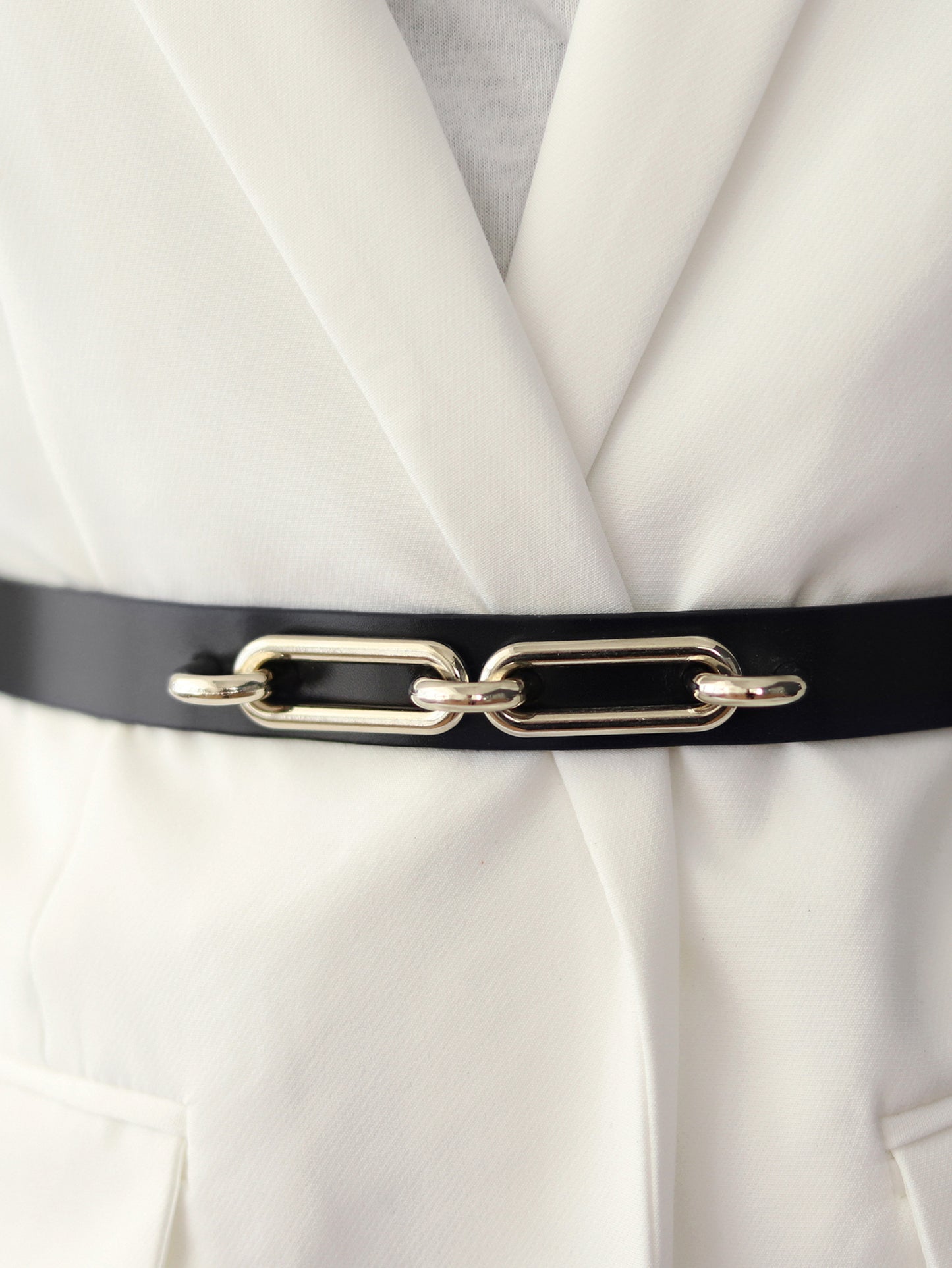 Detailed view of the black skinny leather belt.