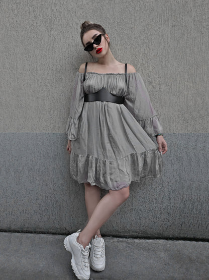 Black leather underbust harness worn with gray dress and white sneakers. 